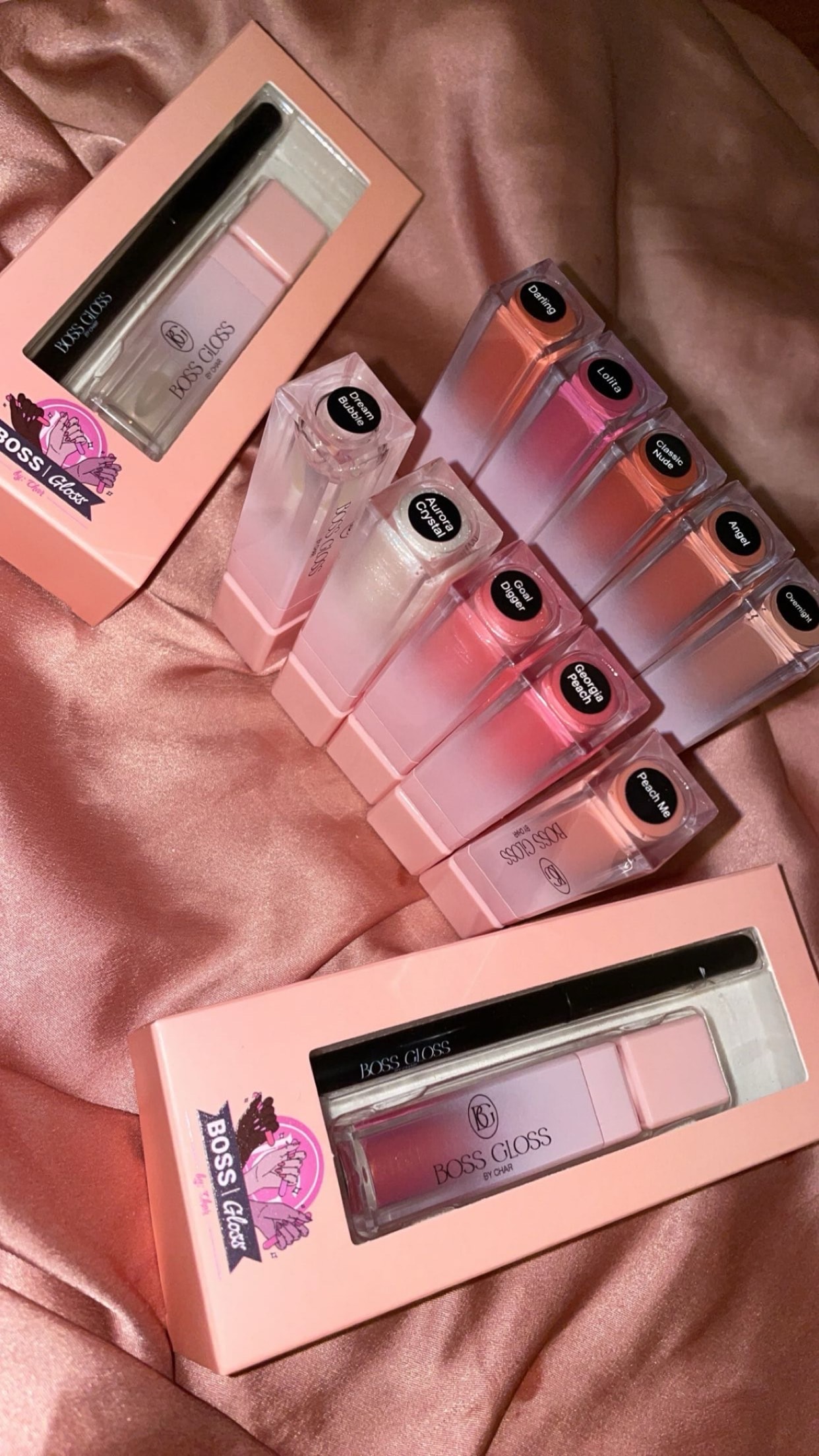 Boss Gloss lip gloss bottles on pink satin